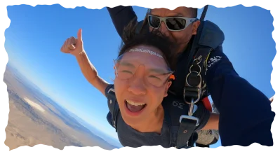 Excited skydiver giving thumbs up mid-air