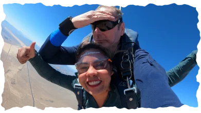 Smiling woman giving a thumbs up while skydiving