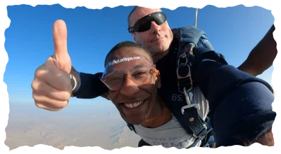 Happy skydiver giving thumbs up over the desert